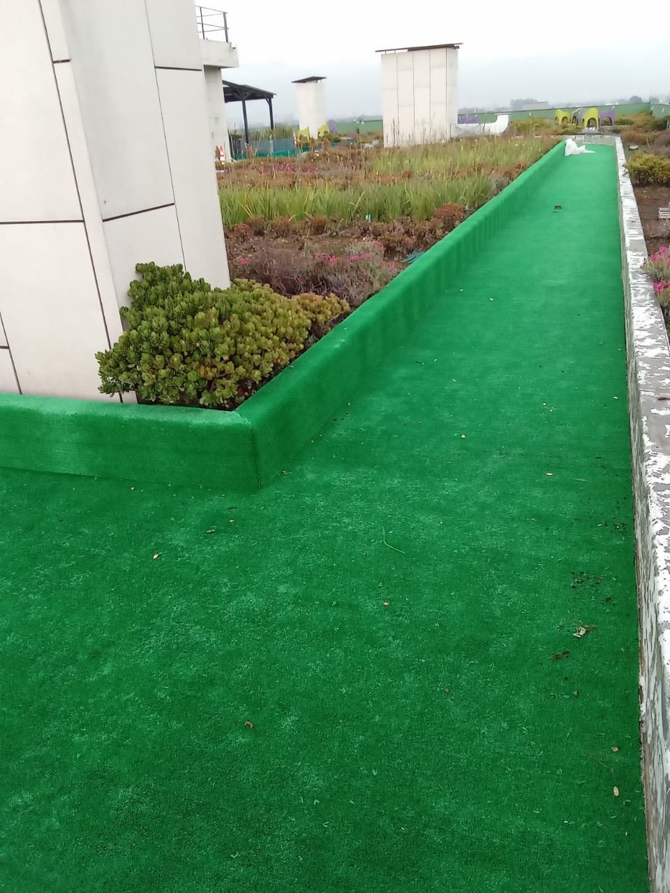 Terraza y jardinera con grama sintética decorativa