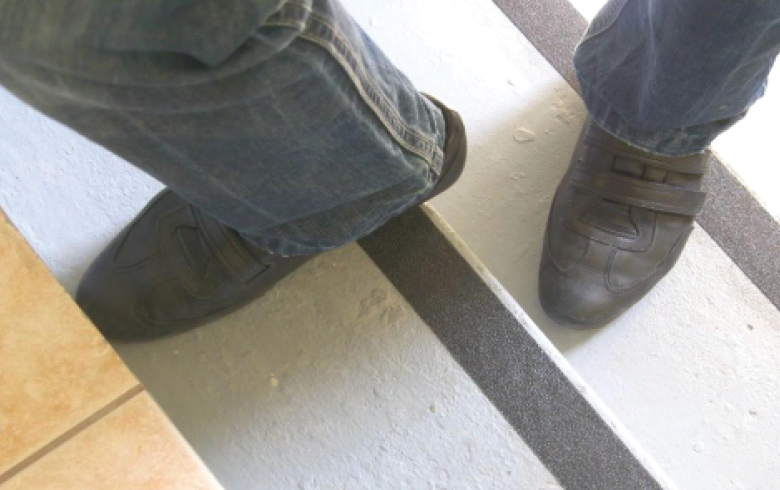 Dos personas usando la banda antideslizante en escaleras